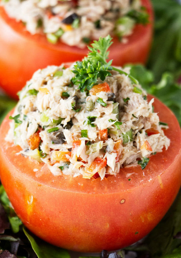 Two tomatoes stuffed with tuna salad.