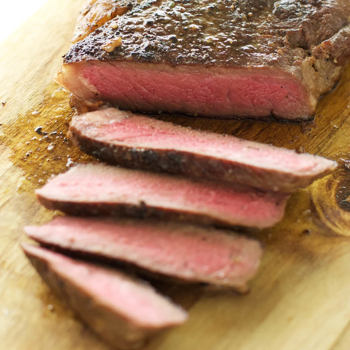 A sous vide ribeye steak on a cutting board.