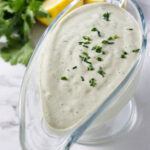 Lemon herb tahini sauce in a dish.