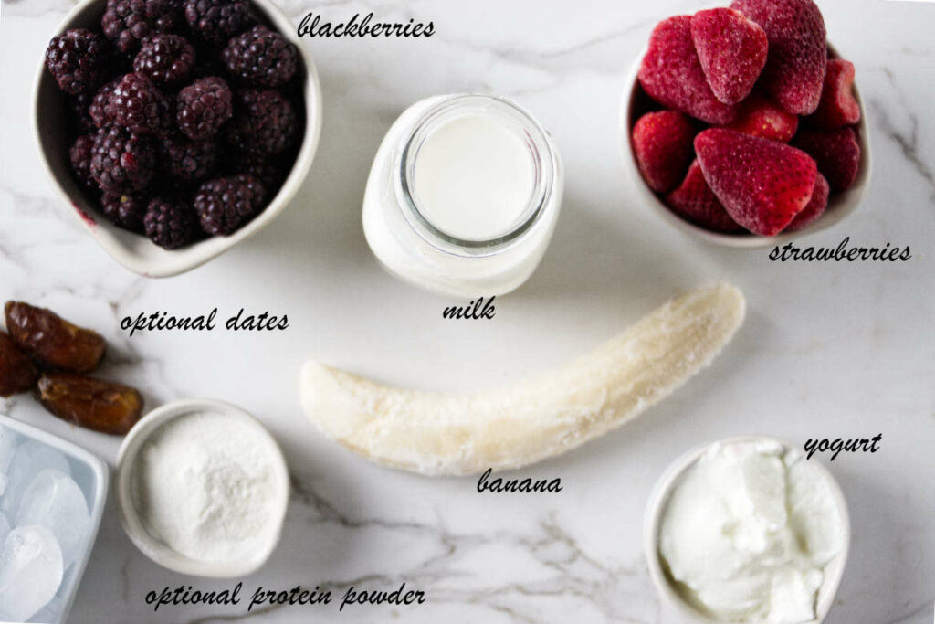 Frozen blackberries, frozen strawberries, a frozen banana, milk, yogurt, dates, and protein powder.