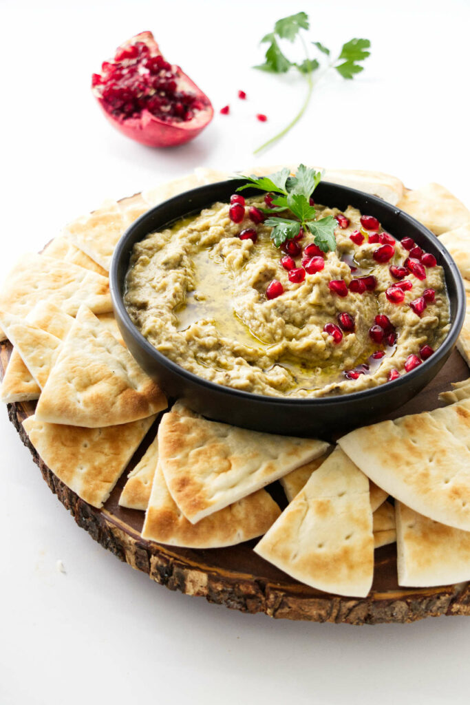 A bowl of baba ganoush topped with pomegranate seeds.
