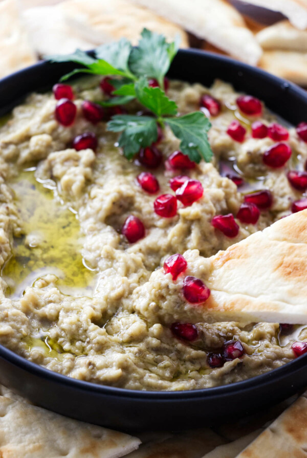 Dipping bread in an eggplant dip.