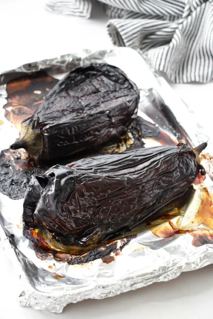 Roasting two eggplants on a baking sheet.