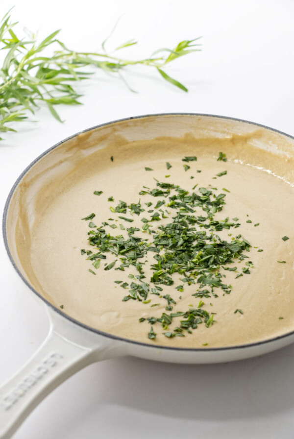 skillet of lobster sauce with chopped tarragon.