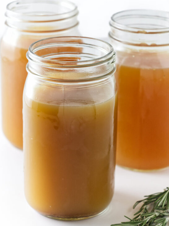 Glass jars filled with homemade chicken bone broth.