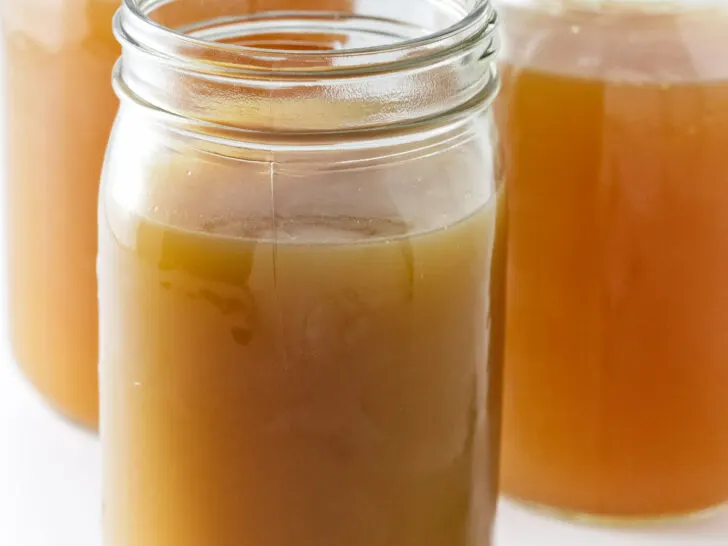Glass jars filled with homemade chicken bone broth.