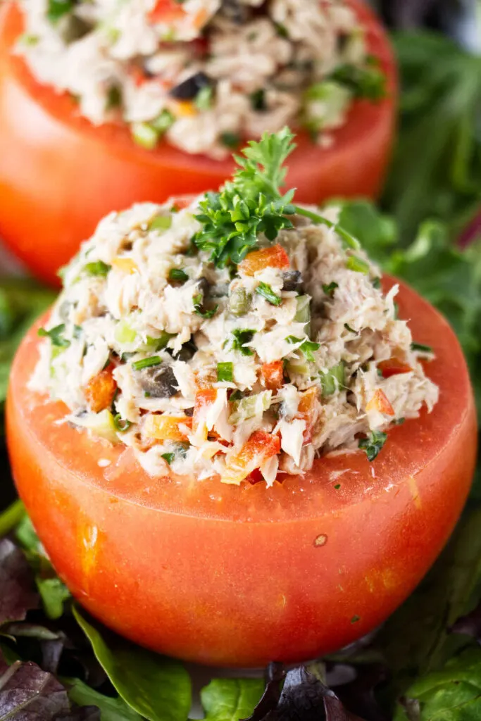 Two tomatoes stuffed with tuna salad.