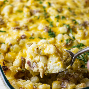 Scooping a serving of cheesy bacon ranch potatoes.