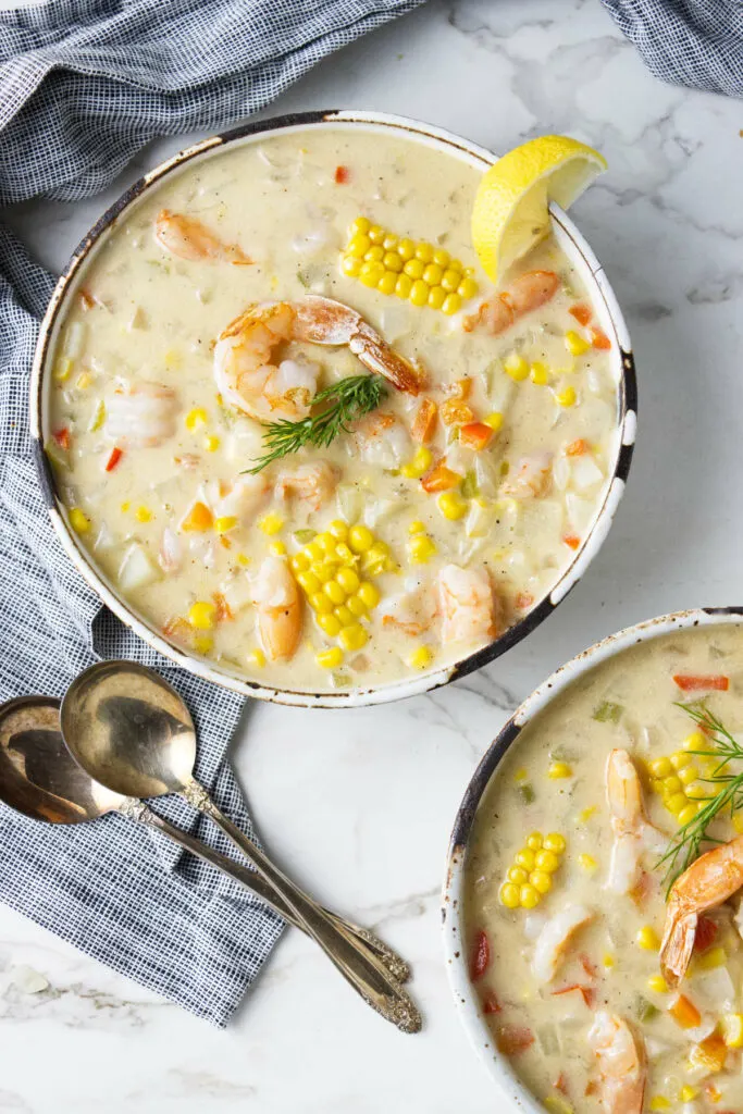 Two bowls of corn and shrimp bisque.