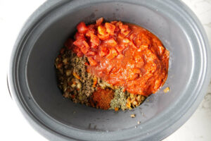 Adding the goulash ingredients to the slow cooker.