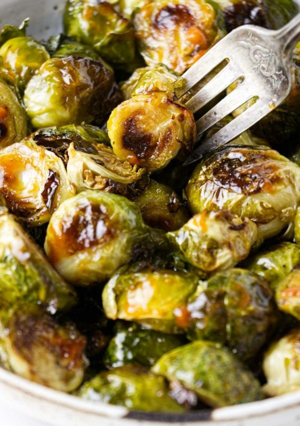 A fork in a dish with sriracha brussel sprouts.