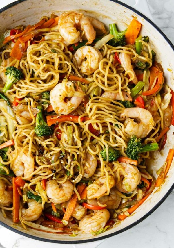 A large skillet of yakisoba with shrimp.