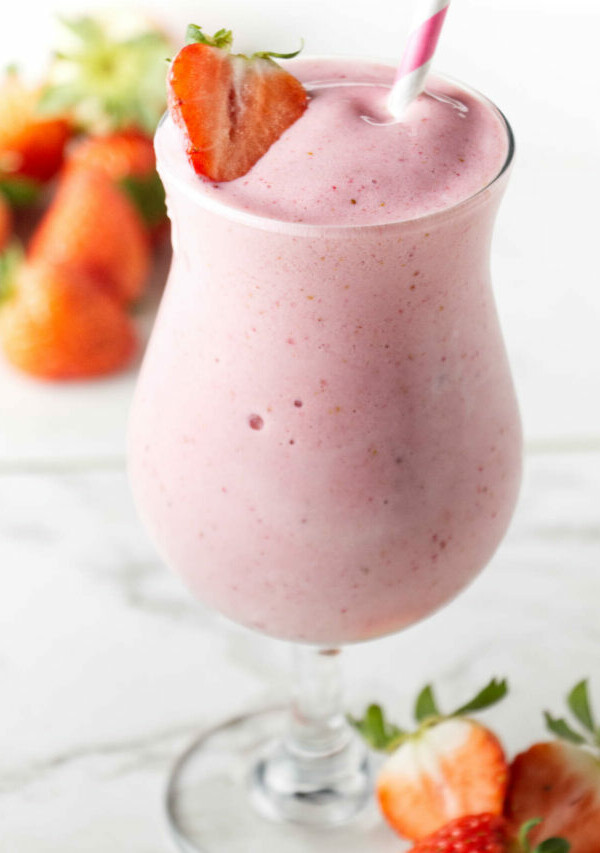 A strawberry protein shake in a tall glass.