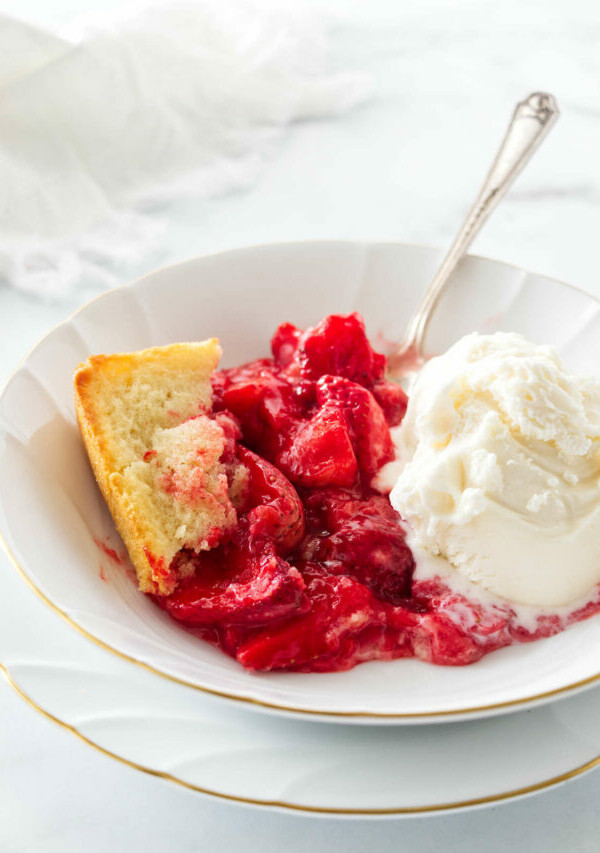 A bowl filled with a serving of strawberry spoon cake.