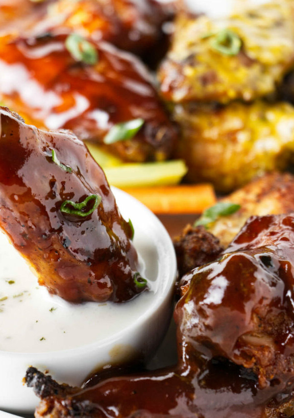 Dipping a chicken wing in ranch dressing.