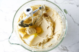 Mixing sugar, butter and eggs in a mixing bowl for cookie dough.