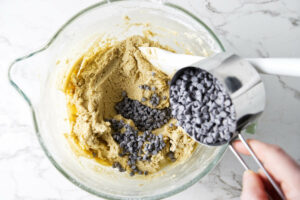 Stirring chocolate chips into cookie dough.