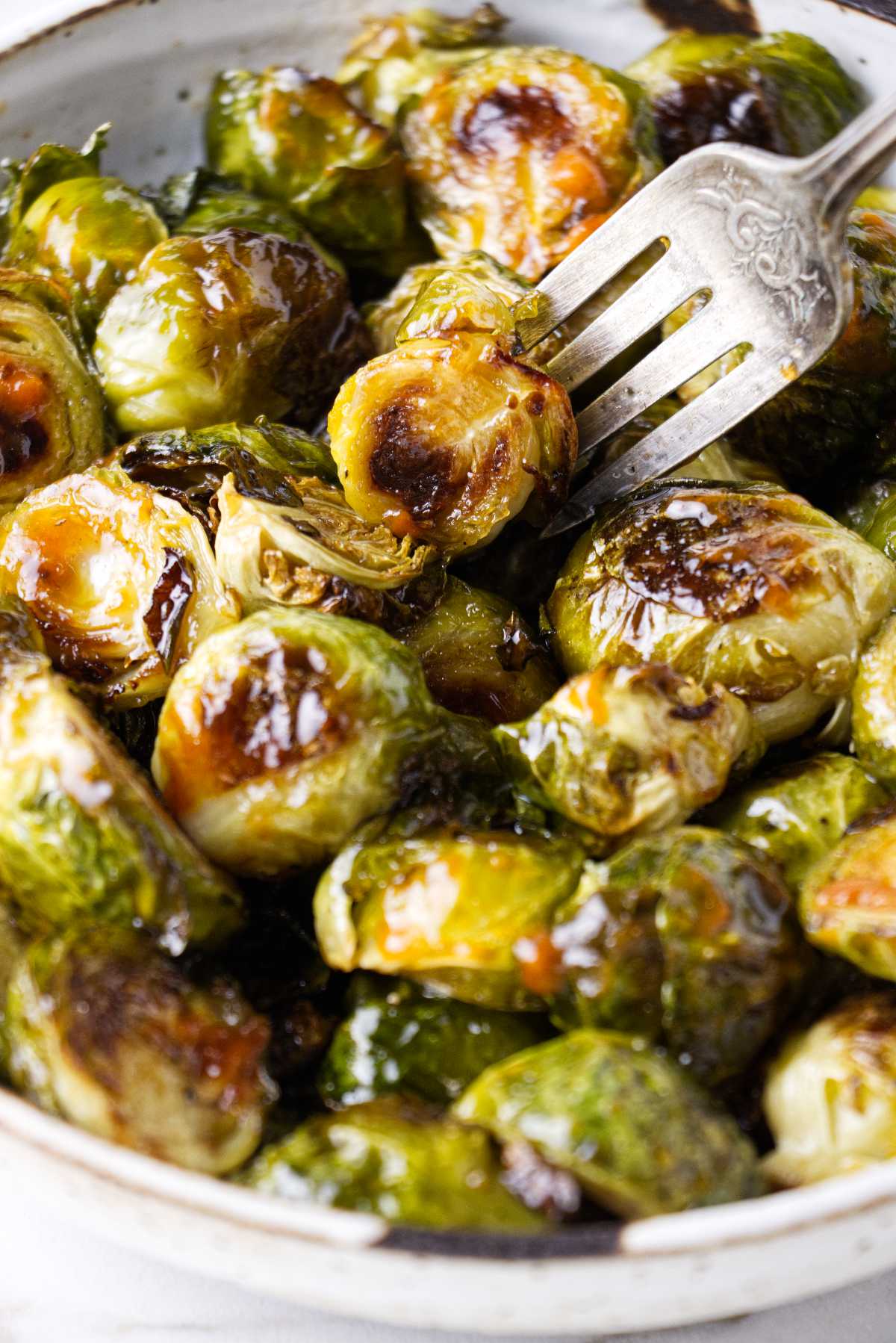 A fork in a dish with sriracha brussel sprouts.