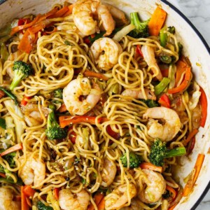 A large skillet filled with shrimp yakisoba.