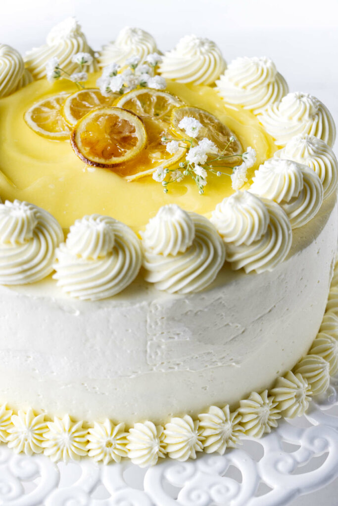 A cake decorated with buttercream, lemon curd, and candied lemons.