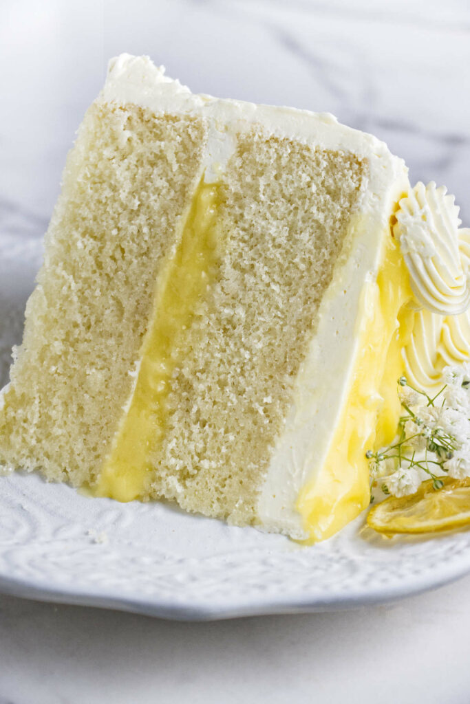 A slice of lemon curd cake on a dessert plate.