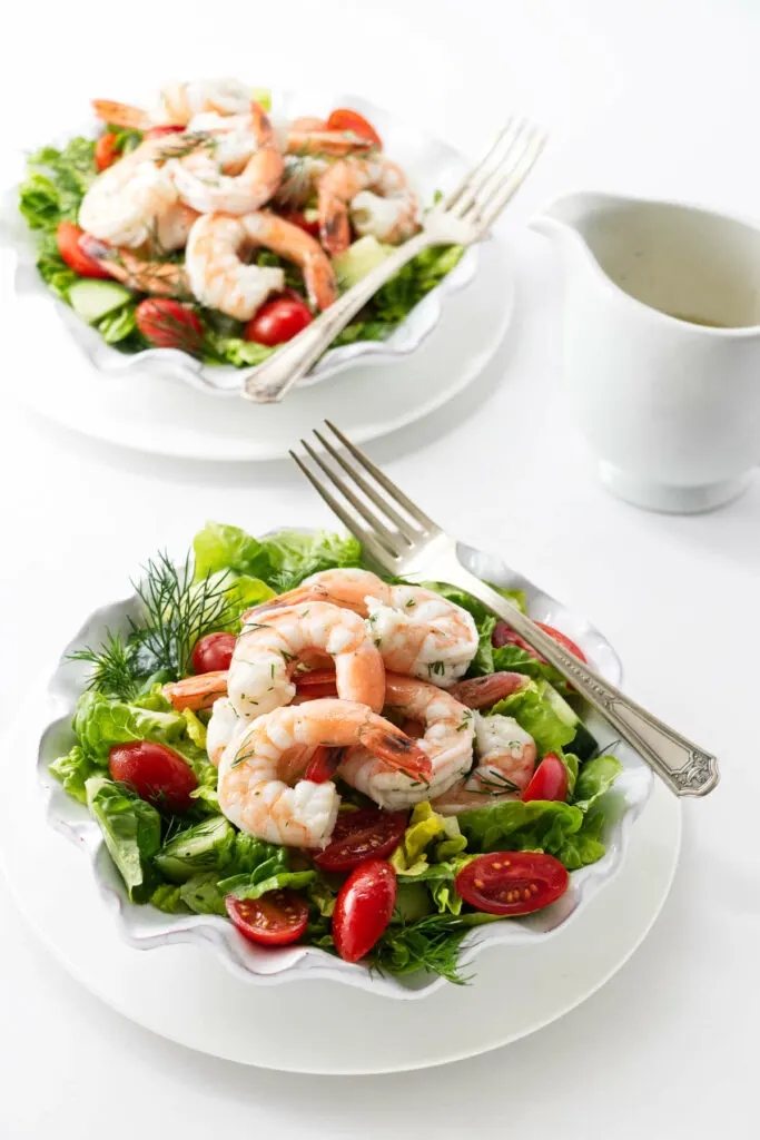 Two green salads with shrimp.