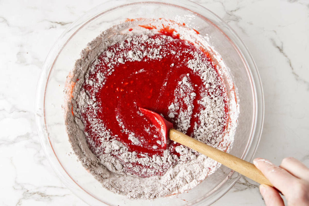 Stirring flour into red velvet batter.