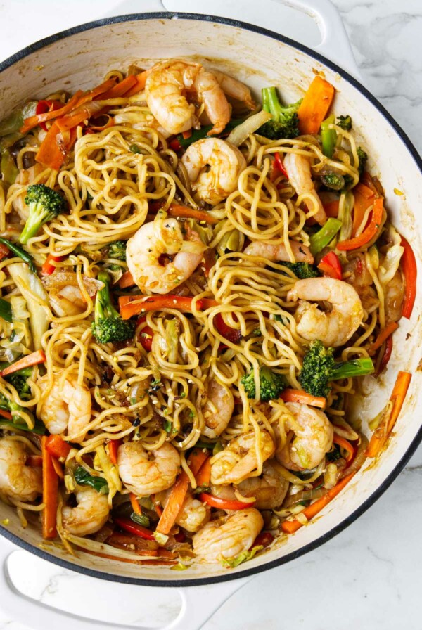 A large skillet of yakisoba with shrimp.