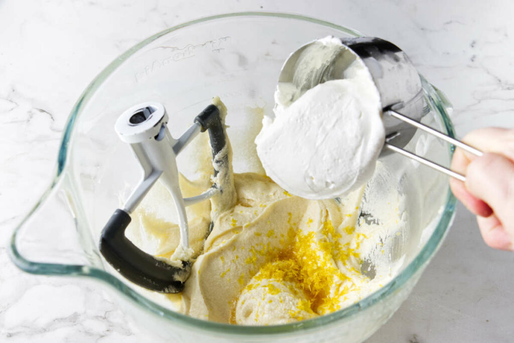 Adding sour cream to muffin batter.