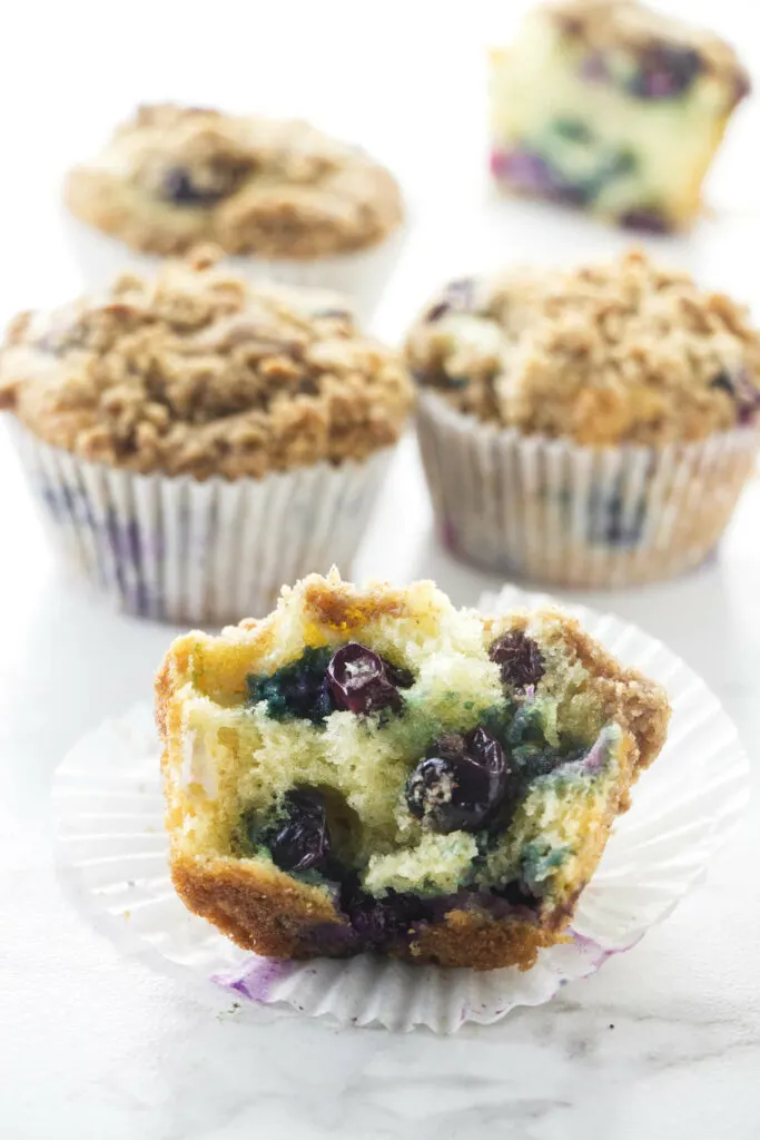 A blueberry muffin broken in half to show the blueberries.