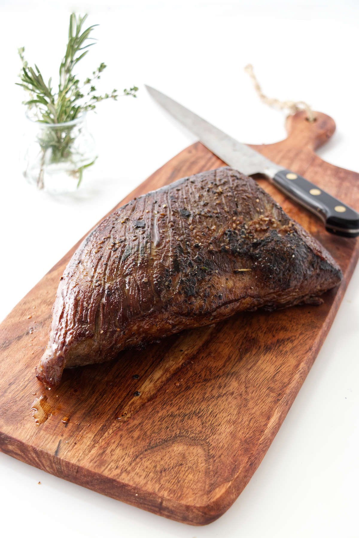 A freshly cooked tri tip roast on a cutting board.