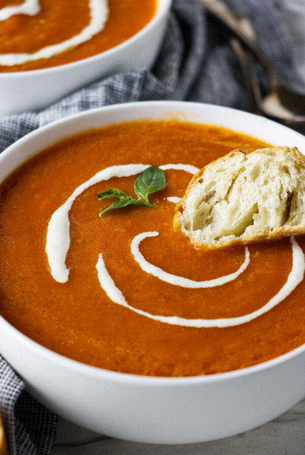 Dipping bread in a bowl of soup.