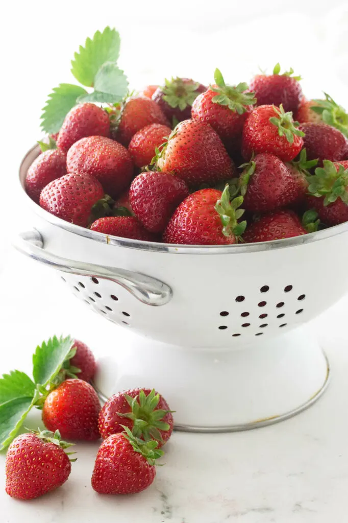 A colander of fresh strawberries.