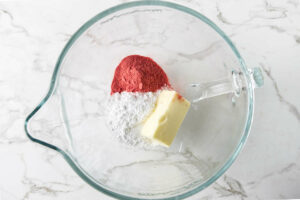 Mixing the powdered sugar, strawberry powder and butter together.