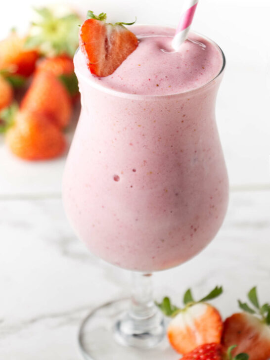 A strawberry protein shake in a tall glass.