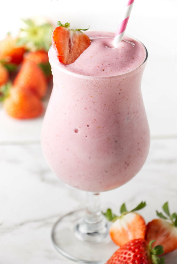 A strawberry protein shake in a tall glass.