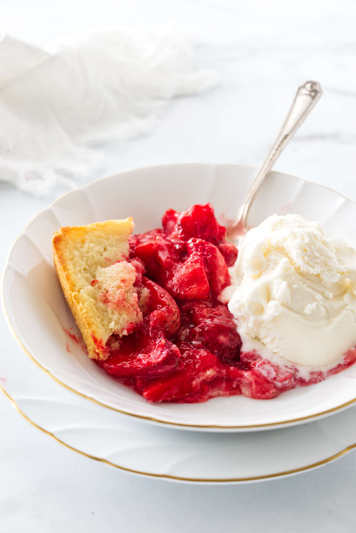 A bowl filled with a serving of strawberry spoon cake.