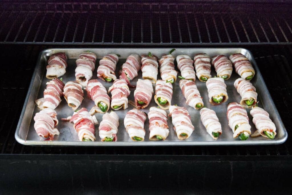 Bacon wrapped jalapeno poppers on a Traeger grill.