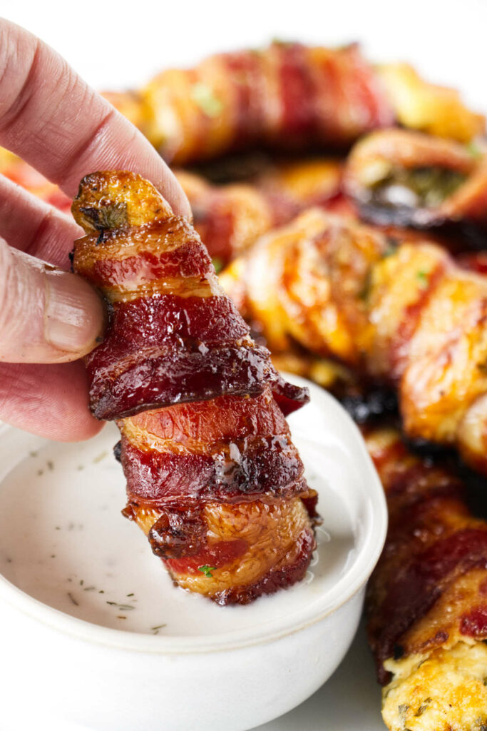 Dipping a jalapeno popper in ranch dressing.