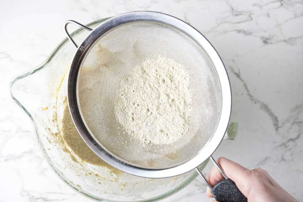 Sifting flour over chocolate chip cookie batter.