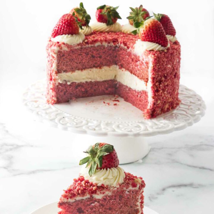 A strawberry crunch cake on a cake plate.