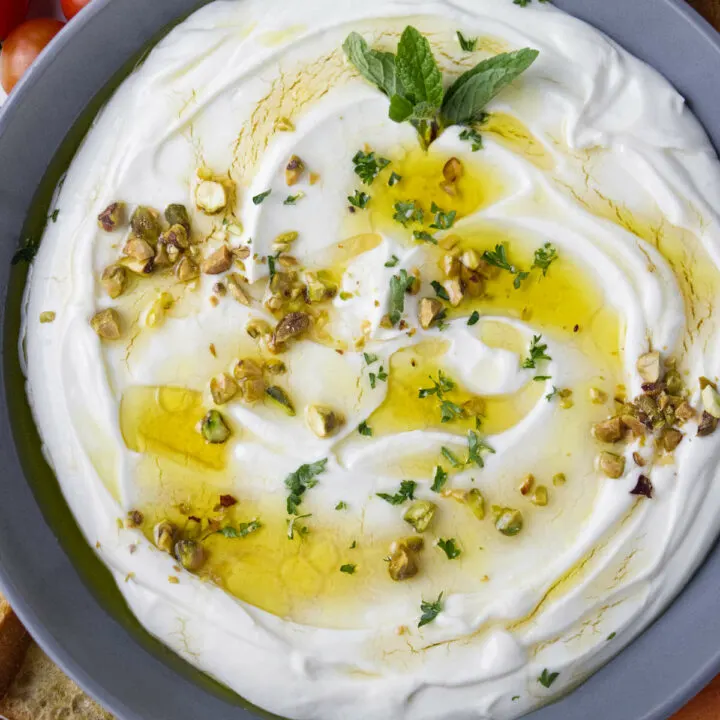 Whipped ricotta in a bowl with honey and olive oil on top.
