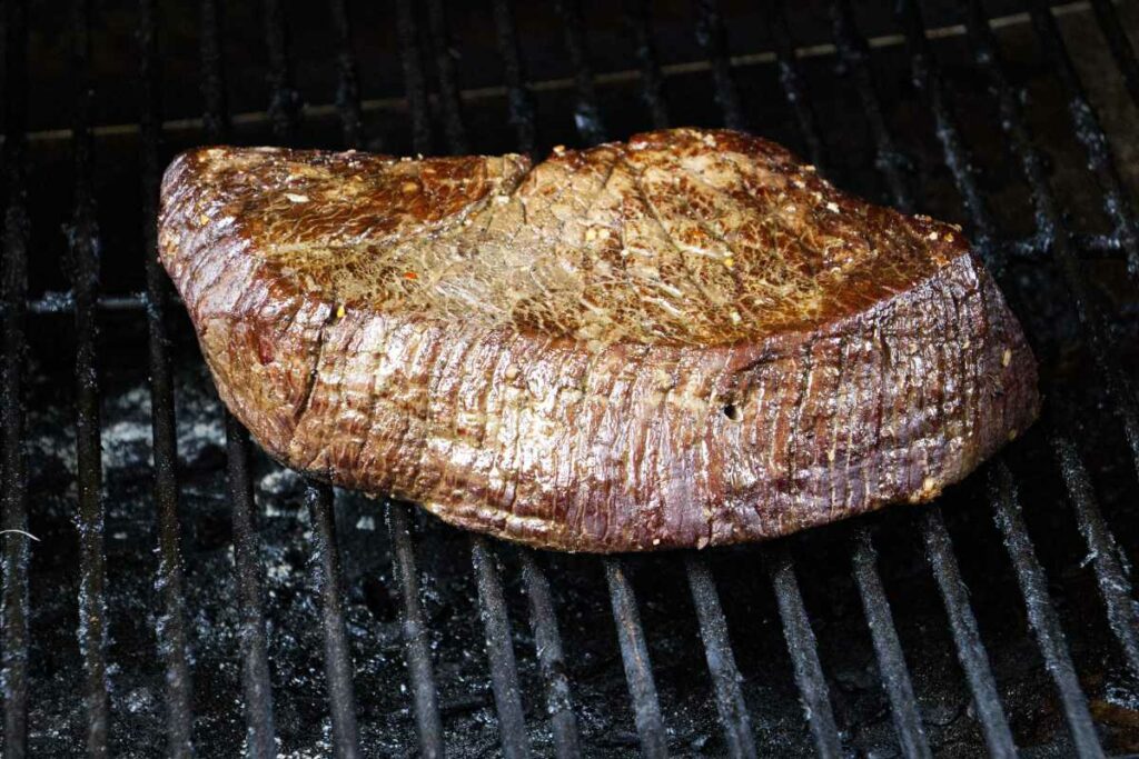 A London Broil on the grill of a pellet smoker.