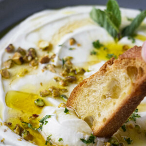 Dipping toast in whipped ricotta.