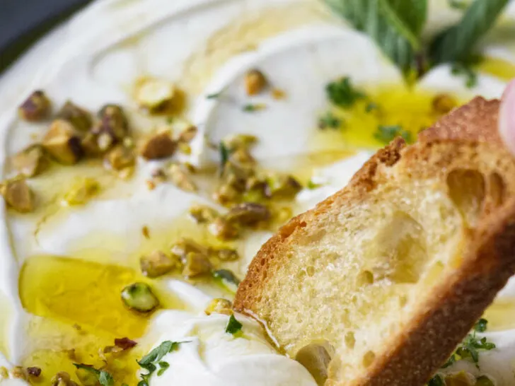 Dipping toast in whipped ricotta.