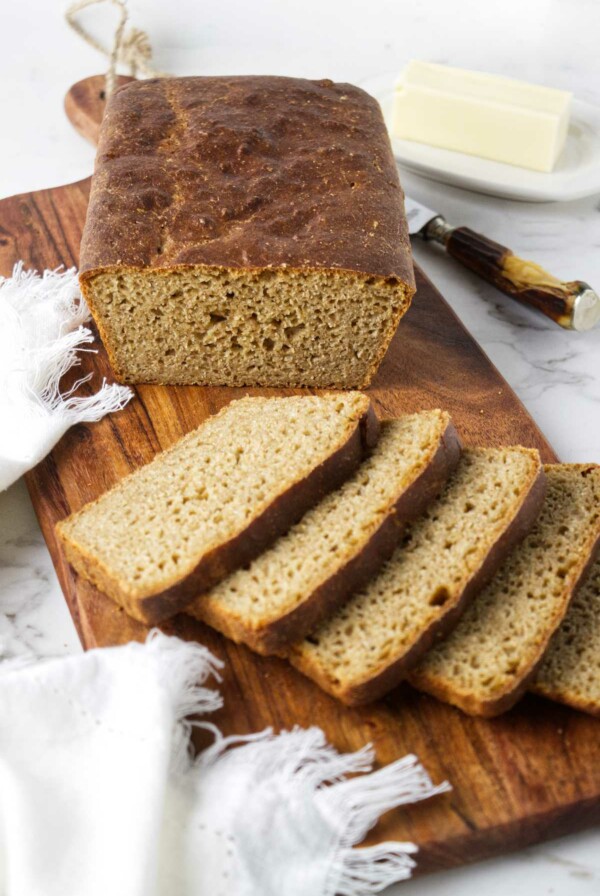 Bread on a cutting board next to butter.