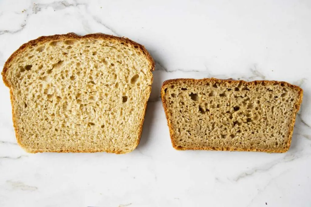 A slice of bread made with 75% einkorn flour next to a slice of bread made with 100% einkorn flour.