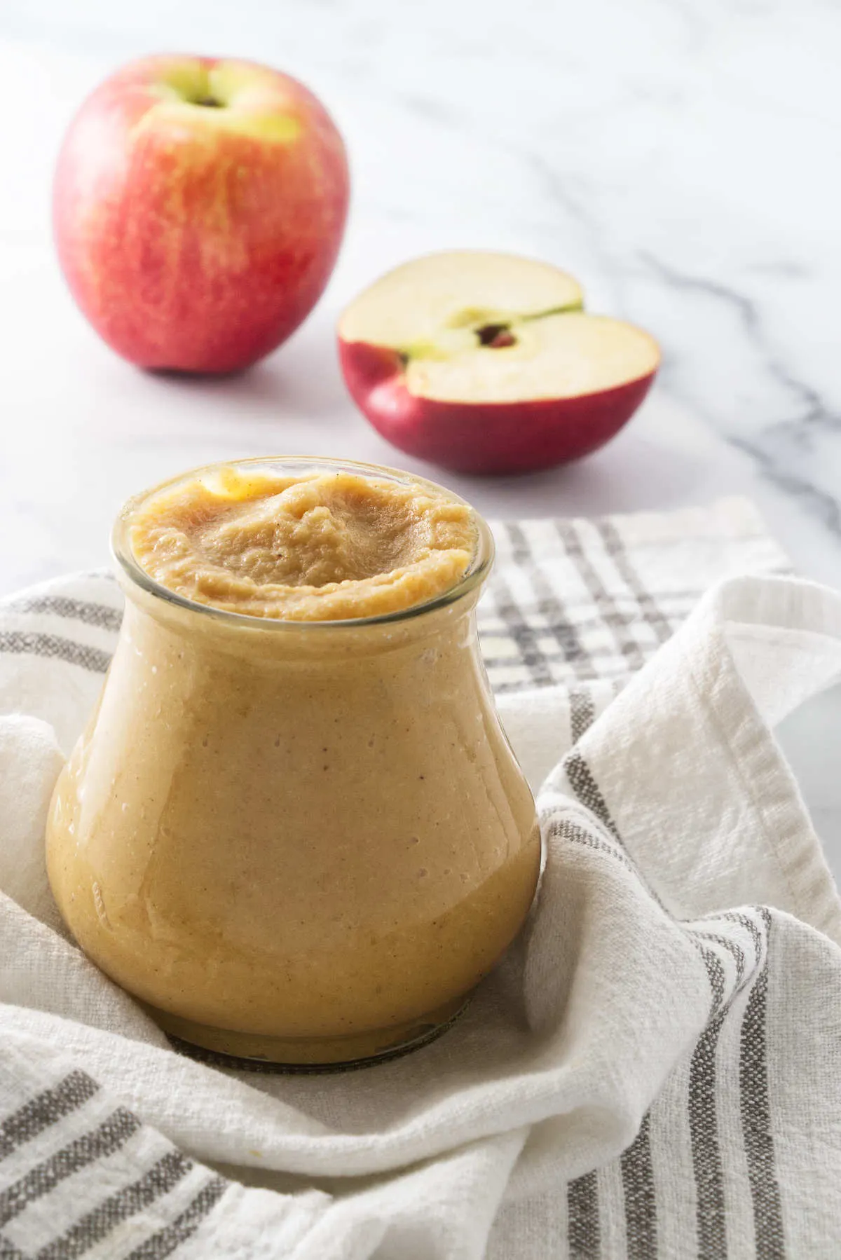 A jar of homemade apple curd on a dish towel.