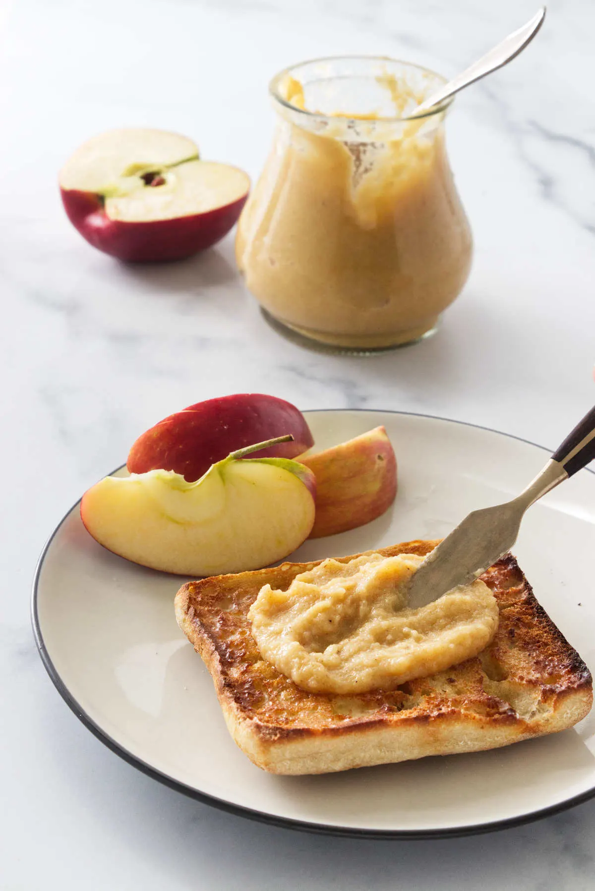 Spreading apple dessert spread on toast.