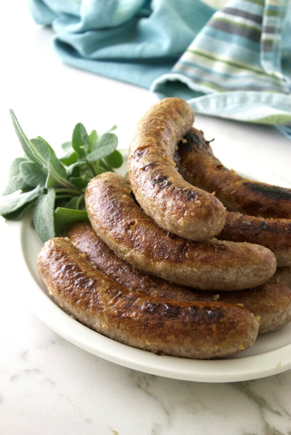 Beer simmered bratwurst on a serving plate.